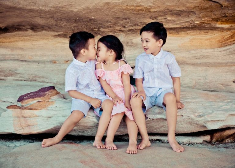 family photo shoots ideas - a picture of three children sitting on a rock together